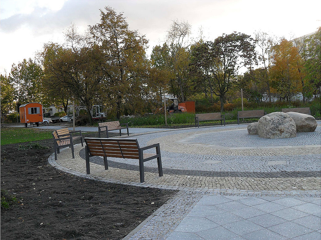 Runder Platz mit Findlingen in der Mitte, Bänke, Beete