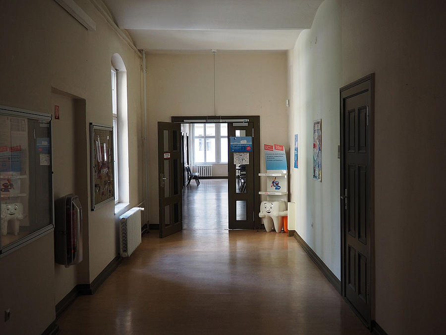 Dunkler Behördenflur mit Warteraum und Aushängen