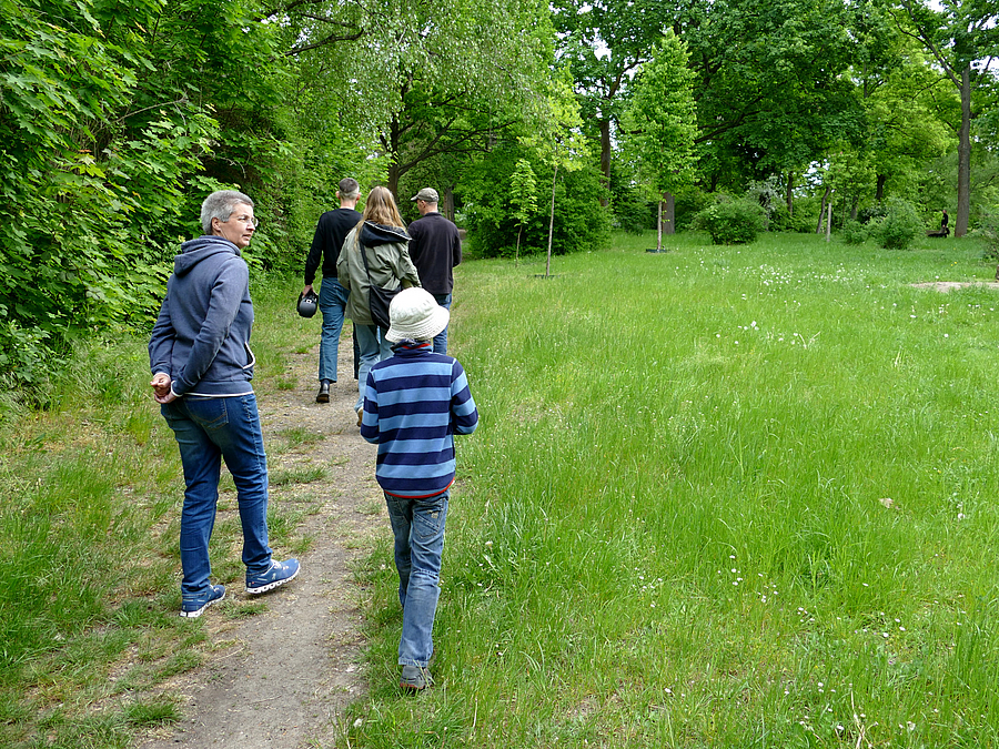 Frau und Kind auf schmalem Weg am Rand einer Wiese