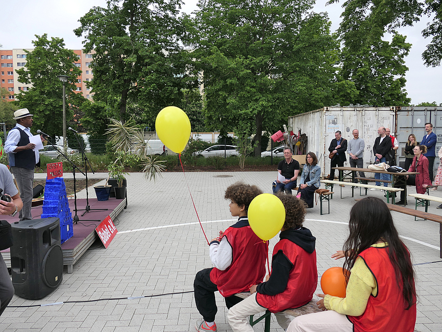 Kinder mit Luftballons im Publikum, Redner Herr Shiferaw