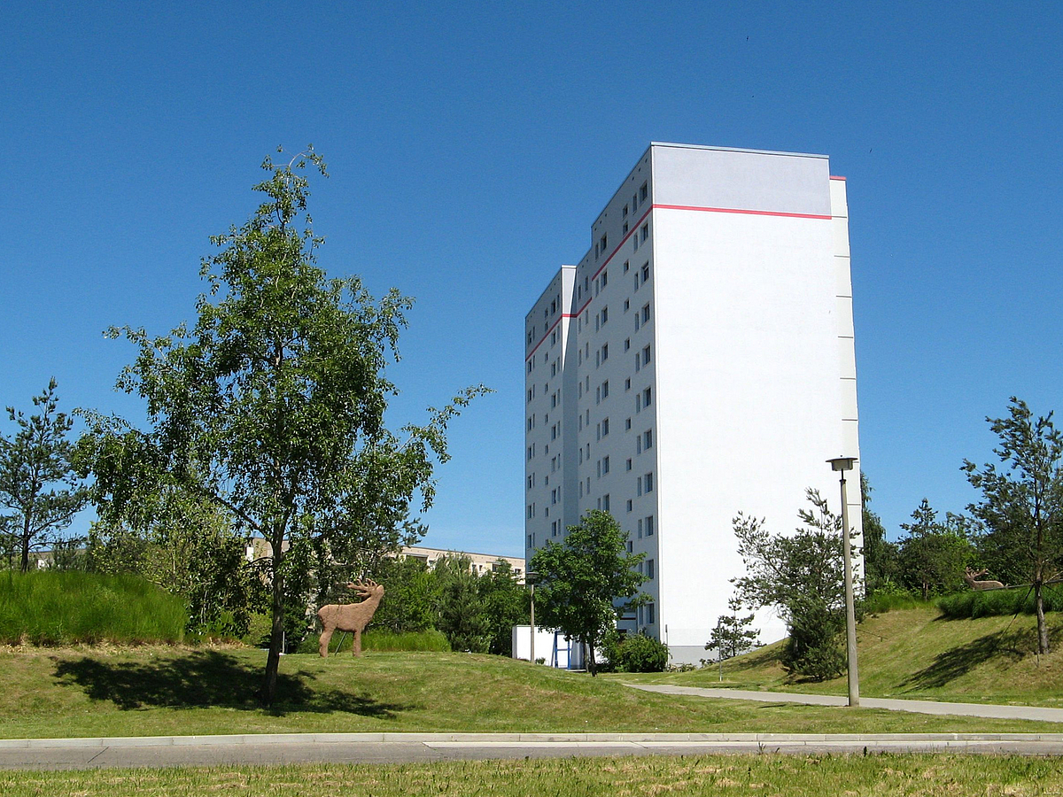 Einzelnes Wohnhochhaus, Kiefern, Hirschskulptur in Braun