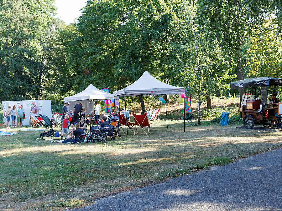 Informationen und Picknick auf der Fläche des historischen Kaffeegartens Park mit Partyzelten und Menschen beim Picknick