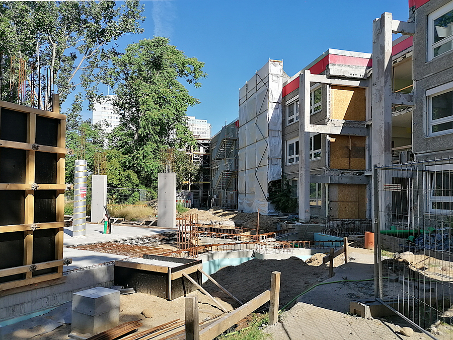 Baustelle mit Bestandsgebäude, teilweise eingerüstet
