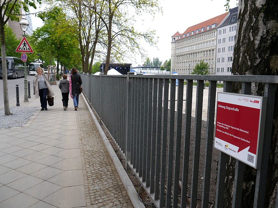 Gehweg mit Geländer und Infoschild Stadtumbau-Förderung