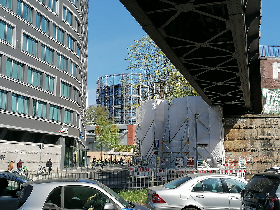 Verkehr unter Bahnbrücke, Blick auf den Gasometer