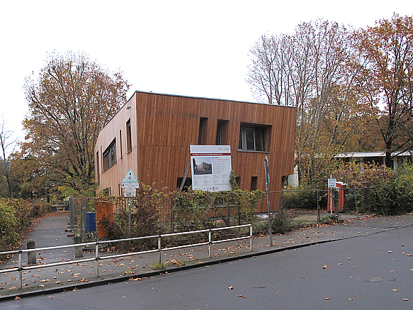 Zweistöckiges, unregelmäßiges Gebäude mit Holzfassade an Straße im Herbst