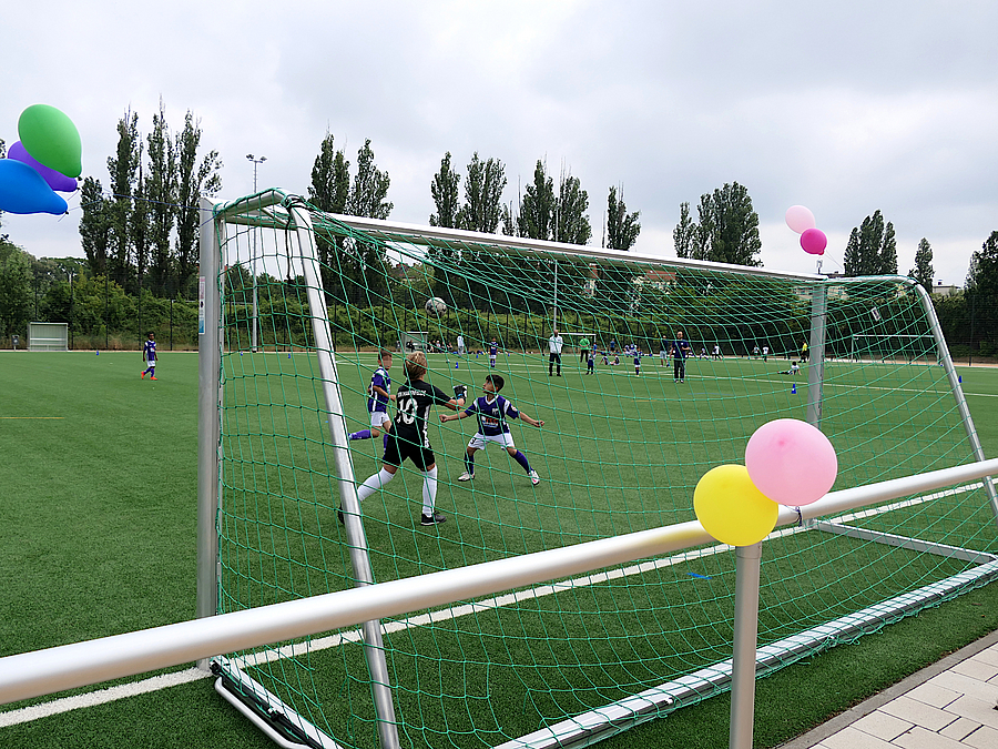 Blick durch Fußballtor auf spielende Kinder