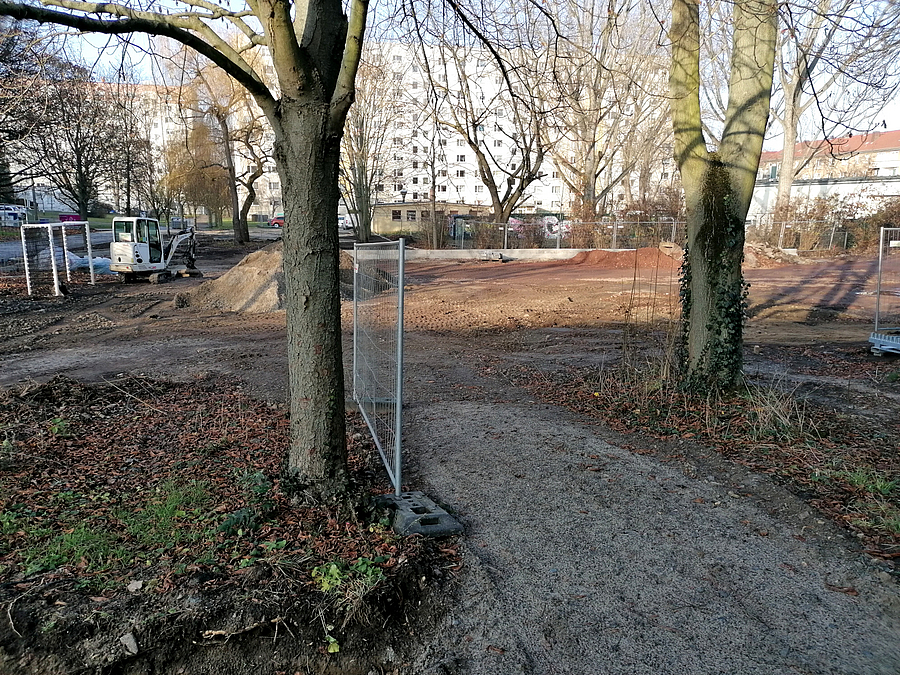 Baustelle mit Kleinbagger und Bäumen