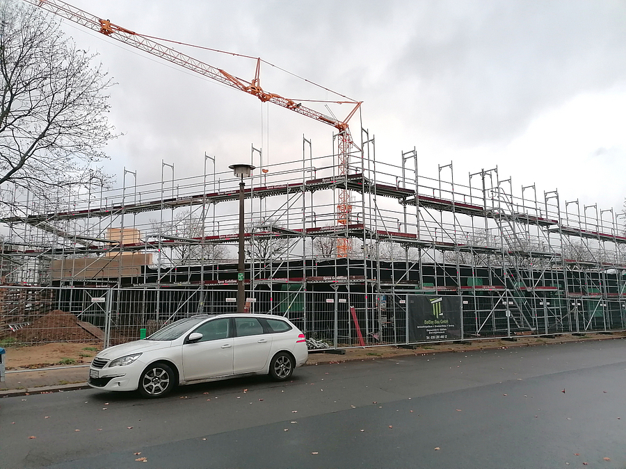 Baustelle mit großem Gerüst über Eck und Kran