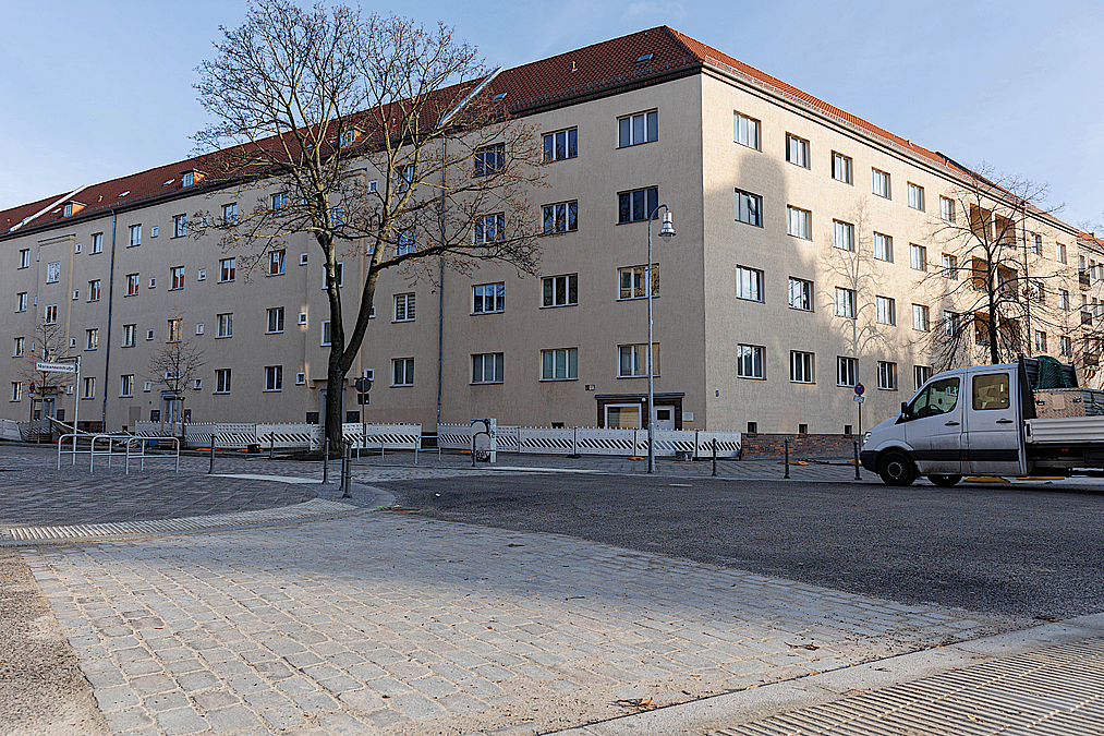 Wohnhaus, Kreuzung, gepflasterter Übergang, Baustelle auf der anderen Seite im Winter