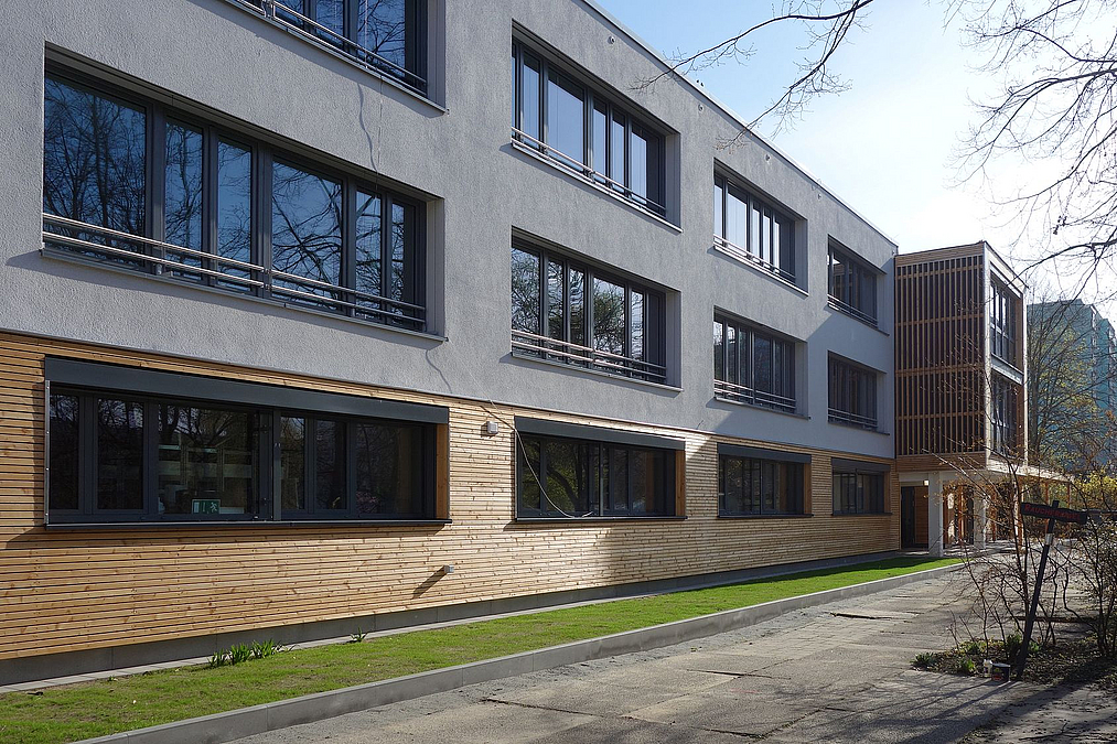 Dreigeschosser mit Holfassade an Erdgeschoss und Erker