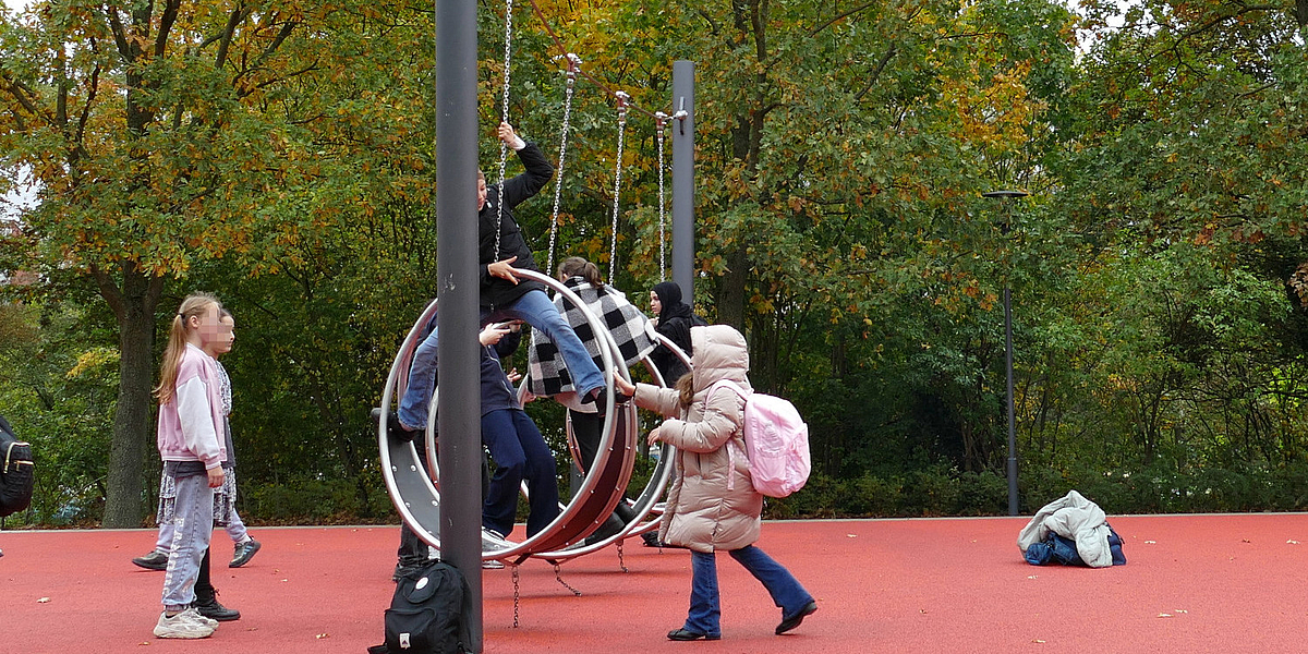 Kinder spielen an großen Ringschaukeln