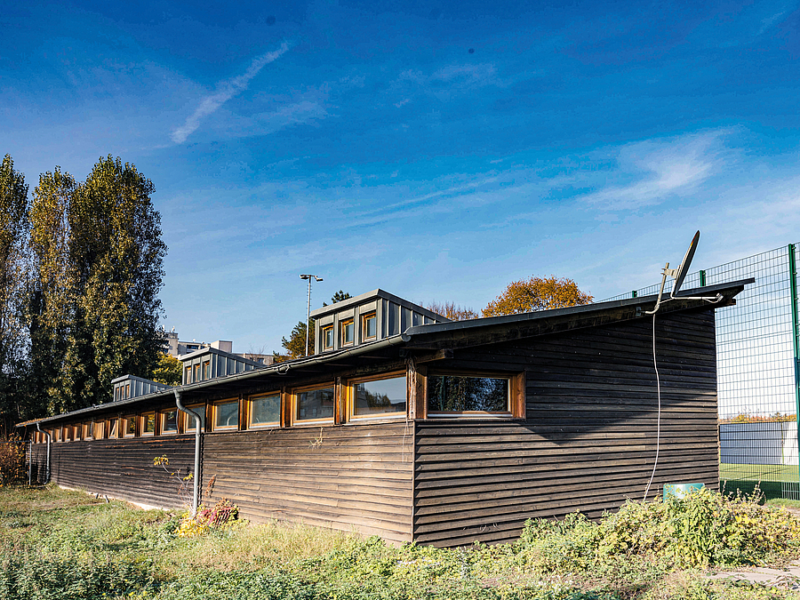 Flachbau aus Holz mit Schrägdach und Fensterband