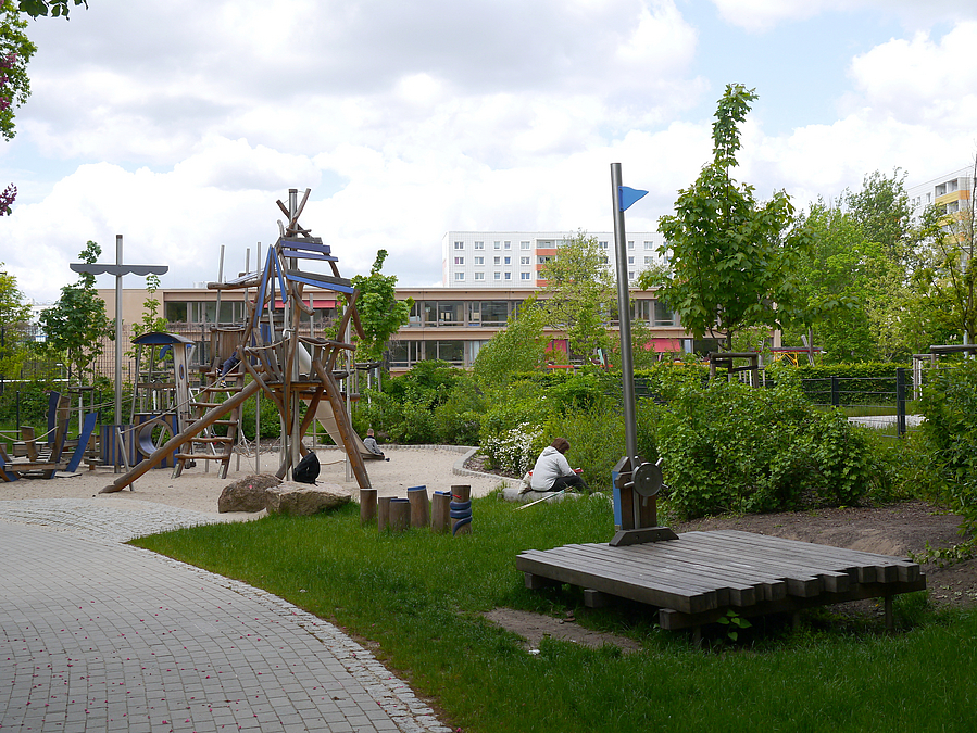 Rasen, Holzdeck, Weg, Spielplatz mit Schiffsmast