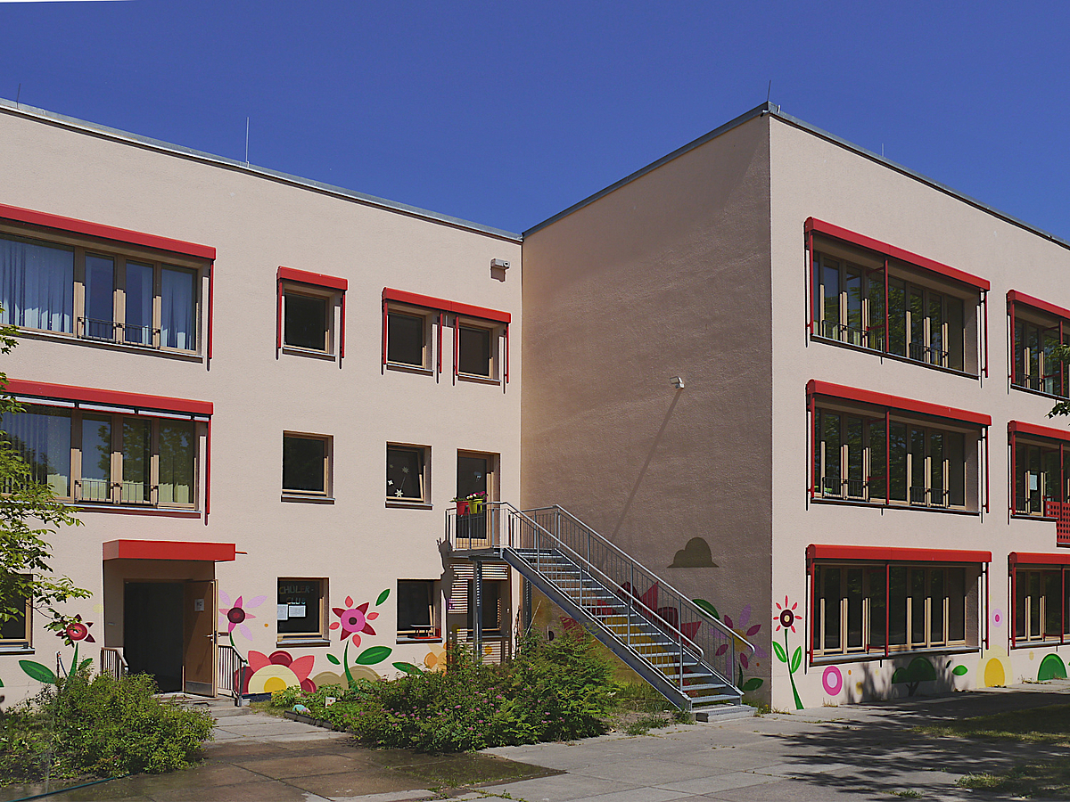 Gebäude mit Rücksprung in Beige mit roten Akzenten und Wandbildern Blumen
