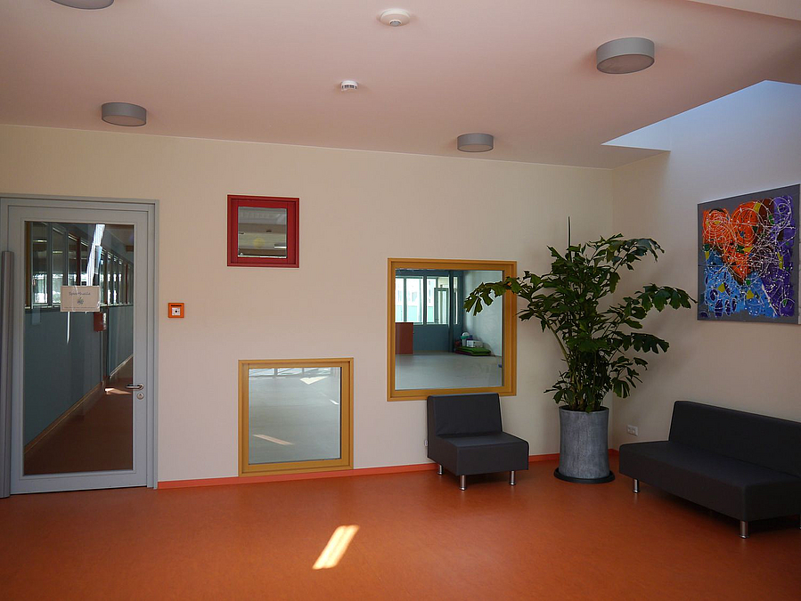 Innenraum mit Tür und unregelmäßigen Fenstern in der Rückwand