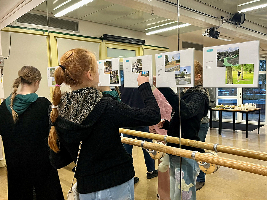 Mädchen beim Bewerten von Spielgeräten bei der Kinder- und Jugendbeteiligung zur Neugestaltung des Spielplatzes vor Plakaten im Tanzsaal