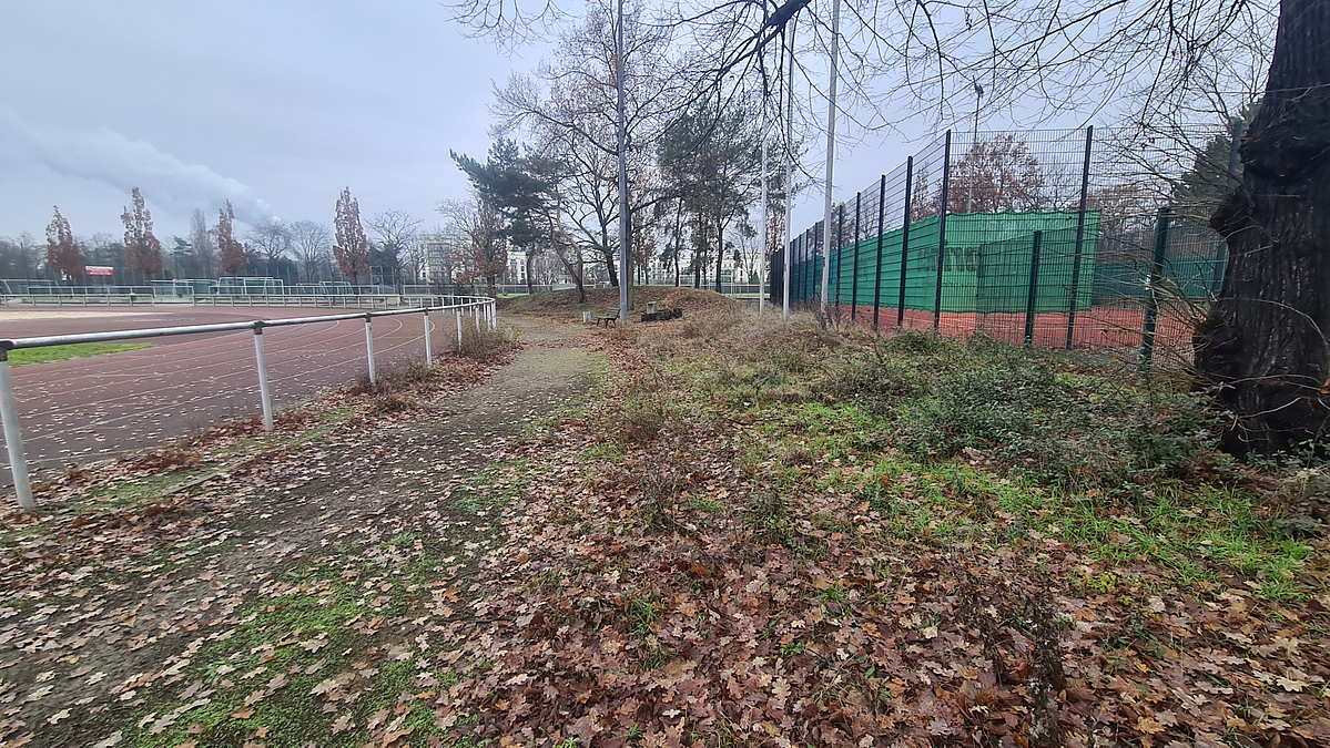 Leichtathletik-Anlage und kleiner Ballspielplatz, dazwischen unbefestigter Weg