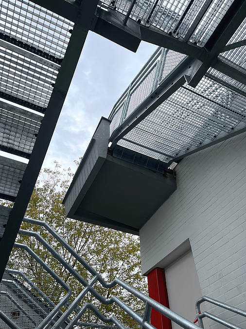 Blick nach oben Blick von unten zum letzten Absatz der Stahltreppe aus Gittern