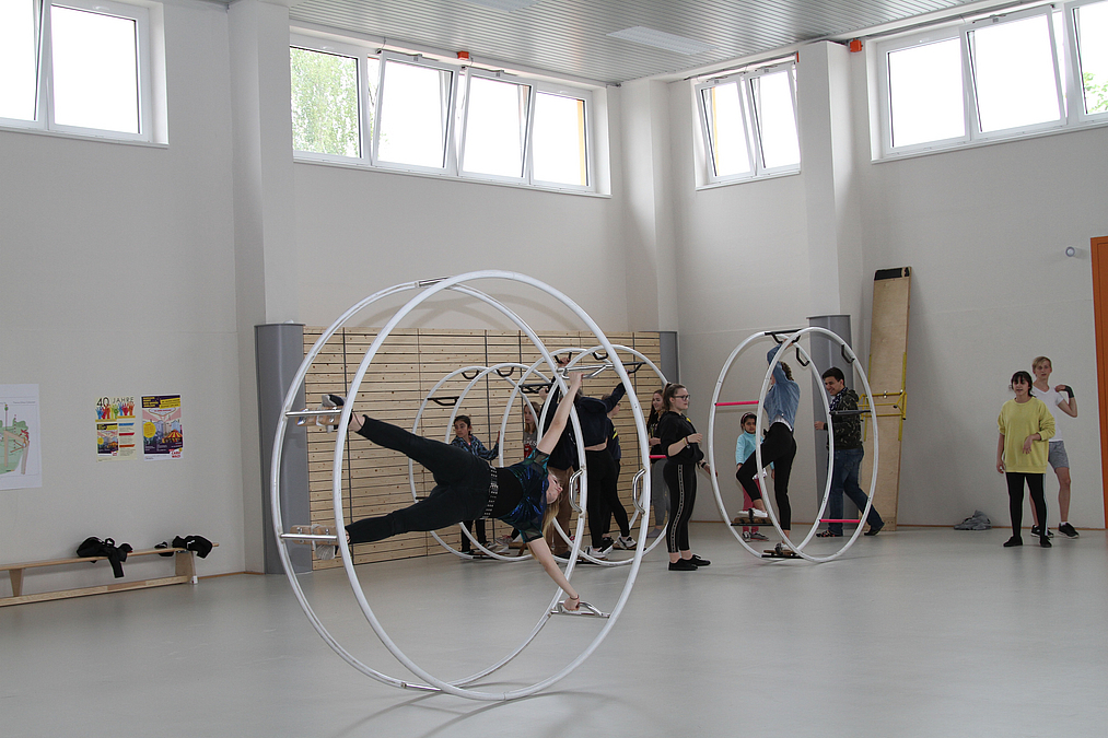 Offenes Training in der neuen Halle am Tag der Städtebauförderung 2019 Drei Rhönräder mit übenden Jugendlichen in heller Sporthalle