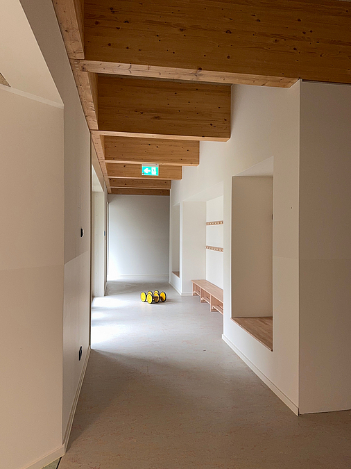Hoher Flur mit tragenden Deckenbalken aus Holz, Sitznische und Garderobe