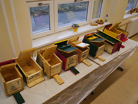 Unterschiedliche Vogelhäuschen auf Tisch in einer Reihe