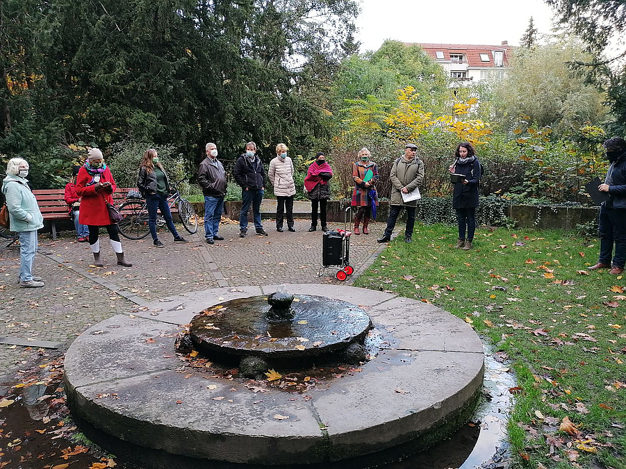 Runde Steinplatte mit Aufsatz im Park, Gruppe bei Besichtigung