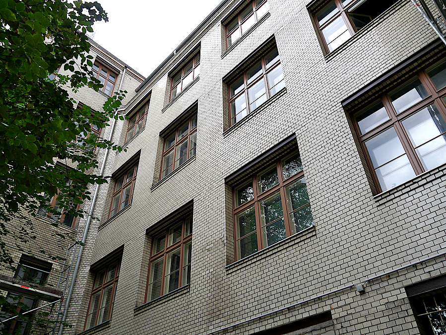 Blick nach oben an Gebäude mit Kacheln, neue Holzfenster