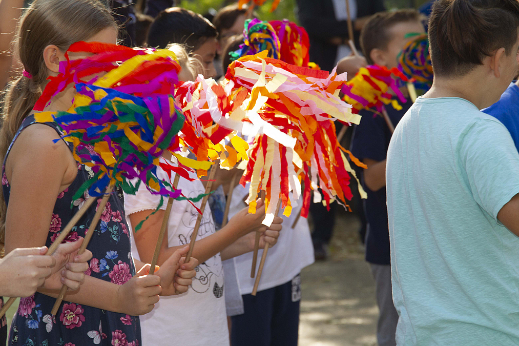 Mädchen schwenken bunte Papierpuschel