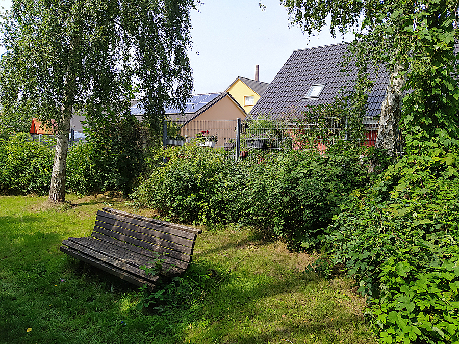 Bank in Grünfläche vor Einfamilienhaus