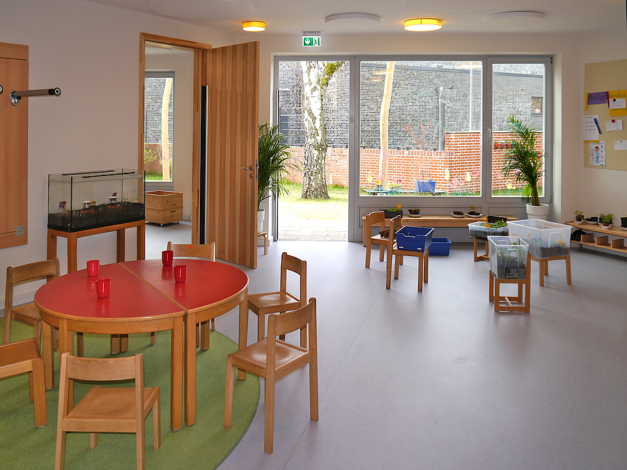 Raum mit bodengleichem Fenster über die gesamte Wand, Kindertische