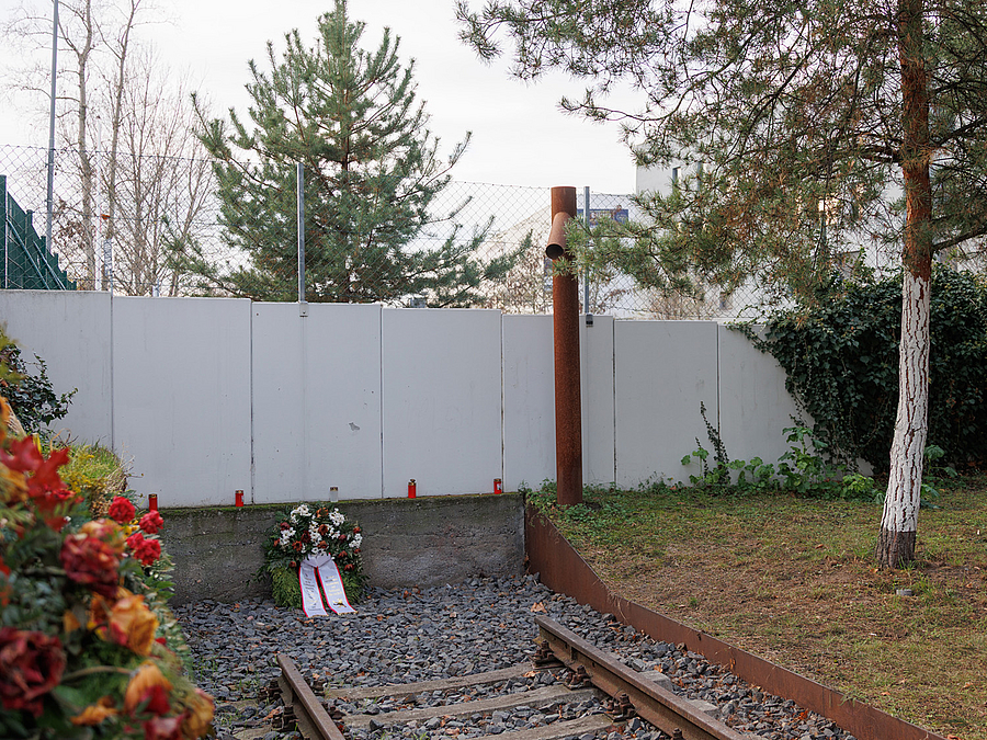 Gedenkmauer mit Kränzen