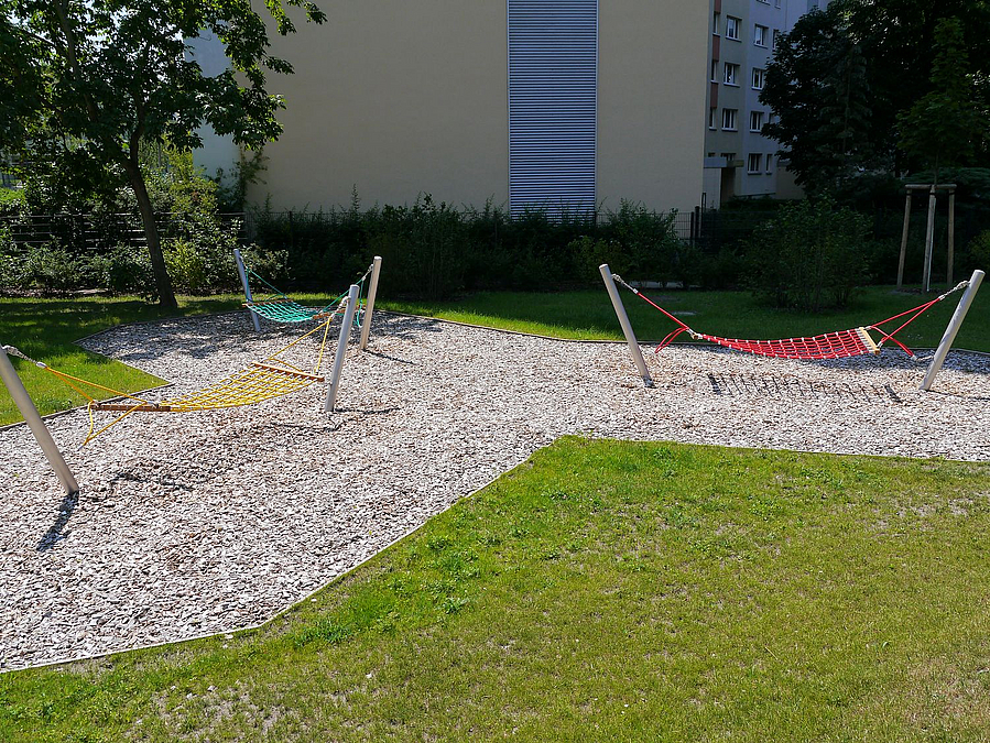 3 Hängematten in Rot, Grün und Gelb auf Holzhäcksel im Rasen