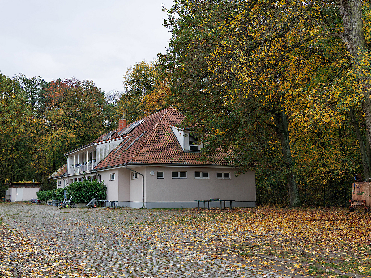 Älteres Älteres Funktionsgebäude mit großem Ziegeldach und Dachterrasse im Herbstmit großem Ziegeldach und Dachterrasse im Herbst
