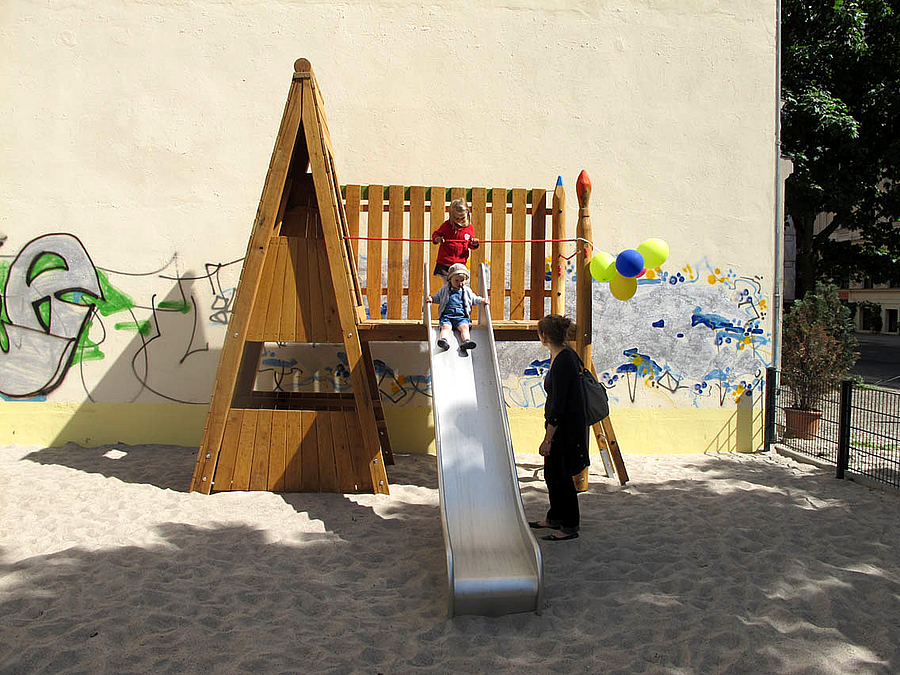 Kleine Rutsche mit Luftballons, 2 Kinder mit Frau