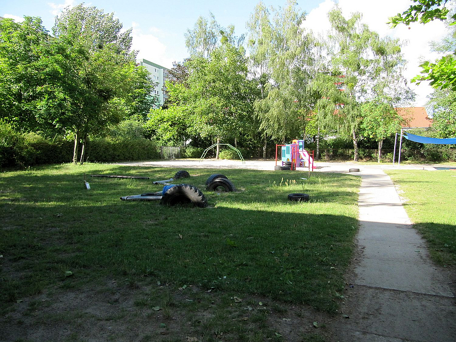 Plattenweg, Reifen und Plastikrohre auf Rasen, Plastik-Spielkombi für Kleinkinder