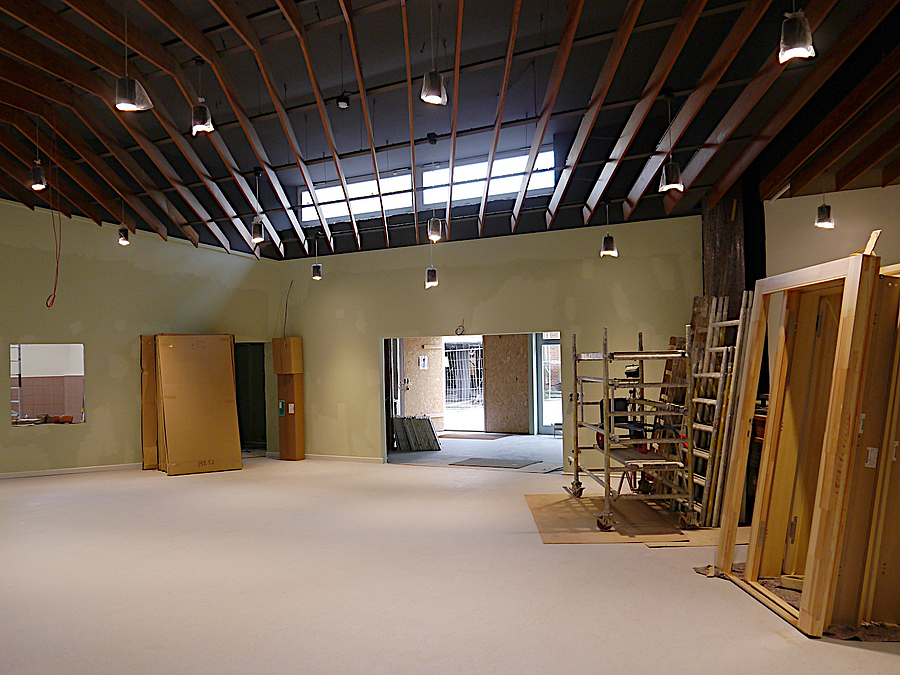 Großer Saal mit Bauteilen aus Holz an den Wänden