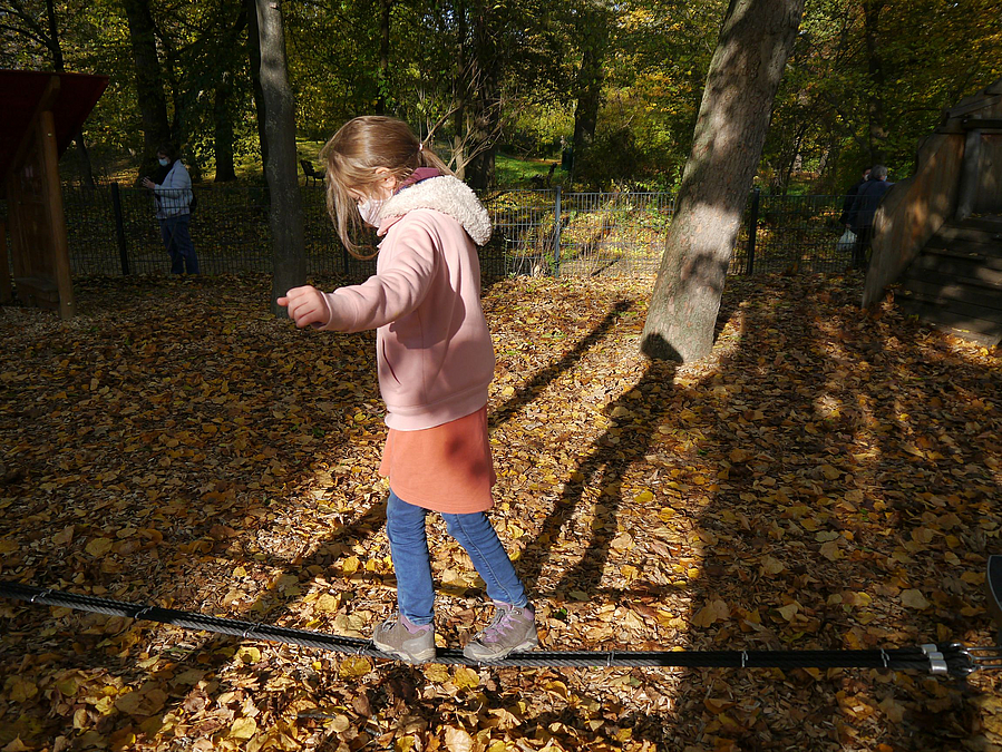 Mädchen balanciert auf Slackline