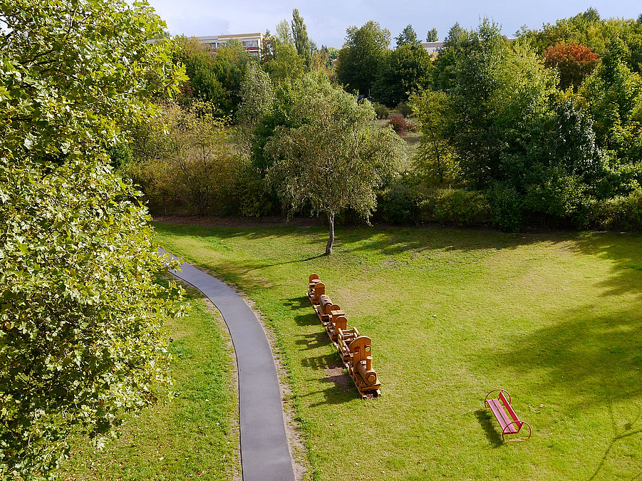 Vogelperspektive auf Rasen mit Rollerbahn aus Asphalt und Holzeisenbahn