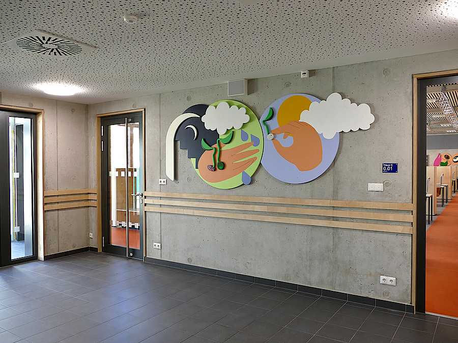3 Türen, rohe Betonwand und aufgebrachte, annähernd runde Kunstwerke in Naturfarben zum Thema Nahrung