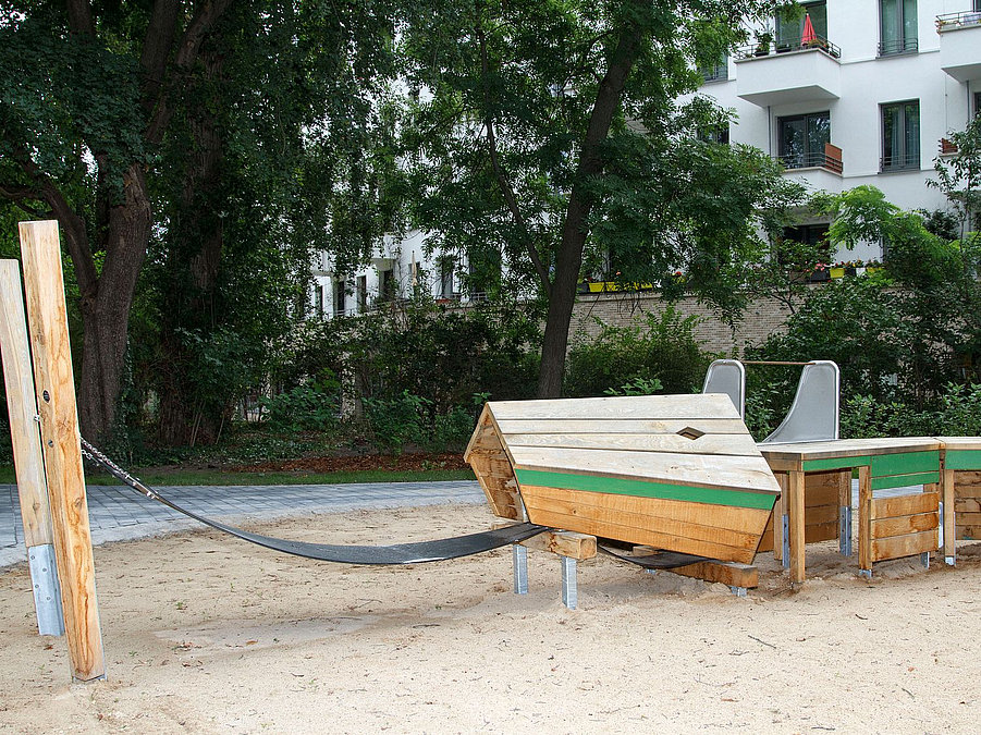 Großer, eckiger Schlangenkopf aus Holz mit Gummimatte zum Balancieren und Schaukeln auf Sand