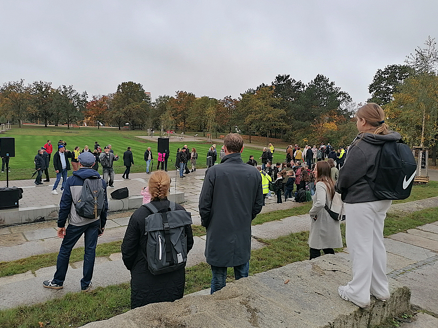 Menschen stehen auf Granitstufen eines modernen Amphitheaters im Park
