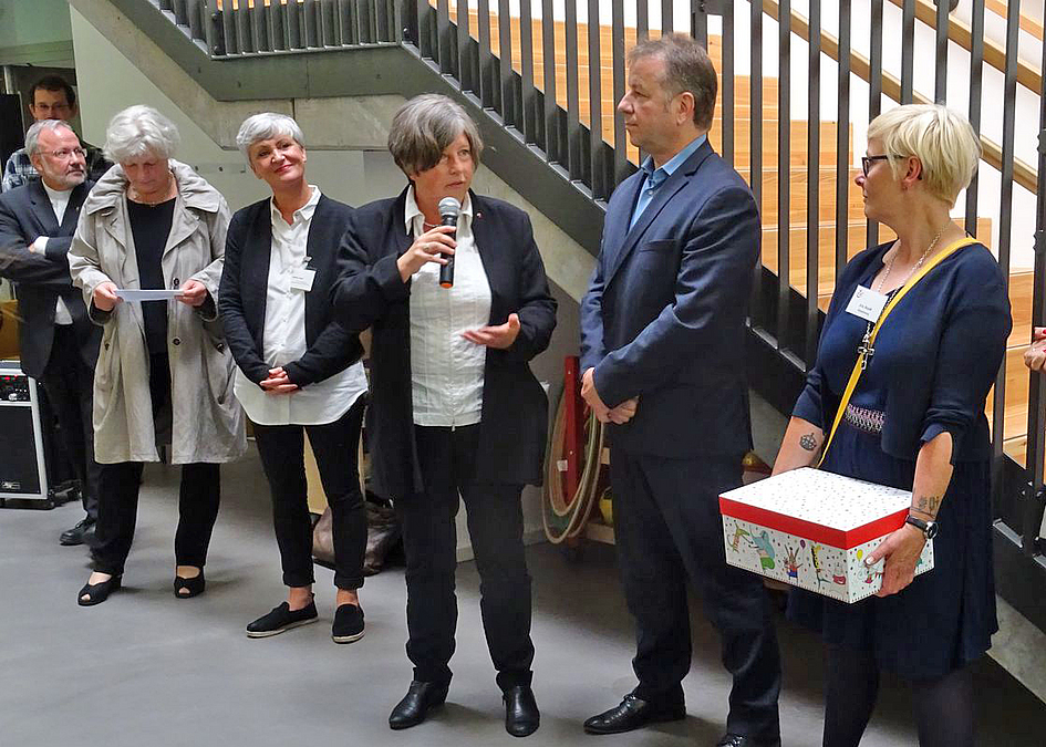 Übergabe eines Geschenks vor Treppe
