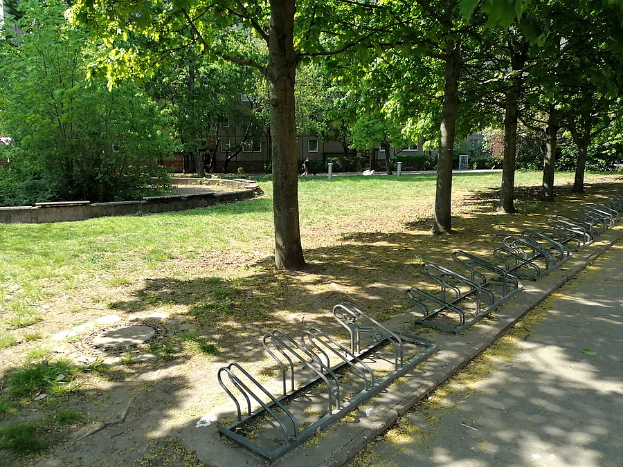 Kleine Fahrradständer unter Bäumen