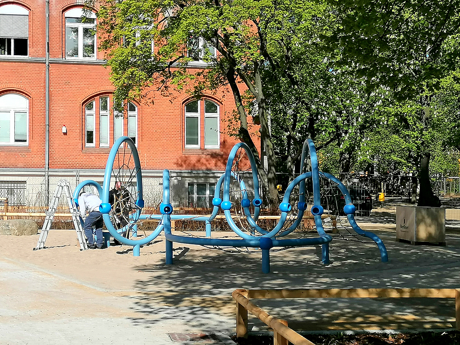 Baustelle mit altem Schulgebäude und Netzspielgerät