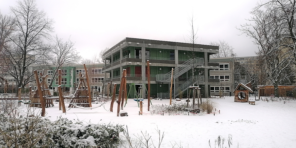 Spielfläche und moderner dreigeschossiger Neubua im Winter