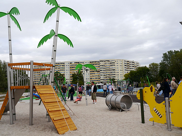 Kleiner Rutschenturm mit Palmen, Tonne, Liegendes Kamel auf Sand