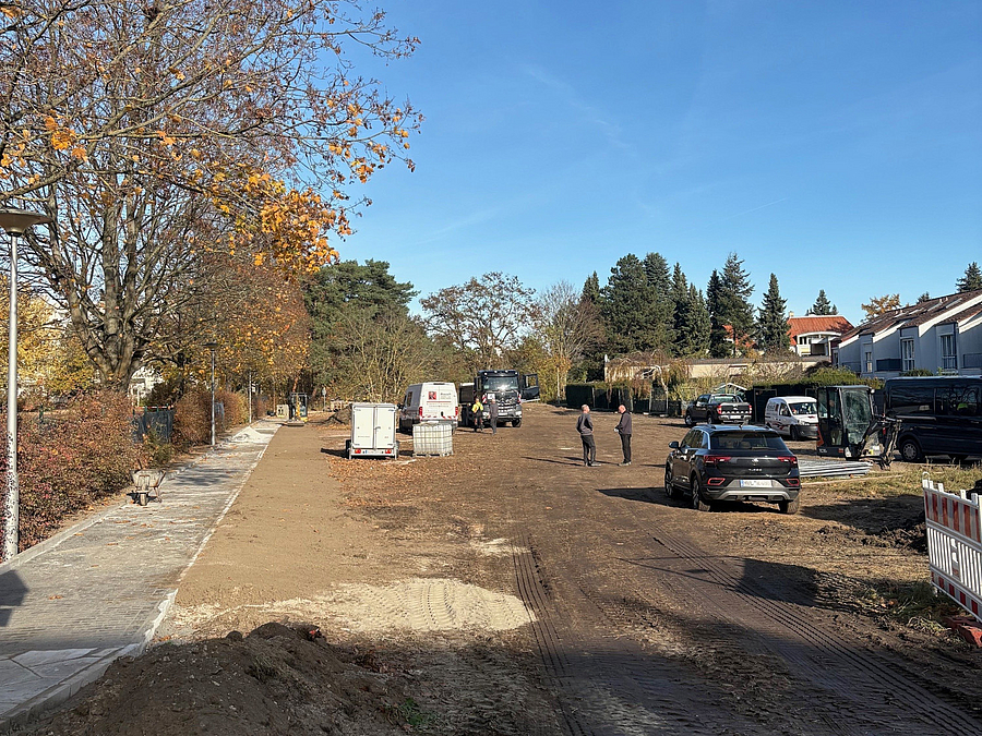 Baustelle mit Fahrzeugen und fertigem seitlichen Gehweg