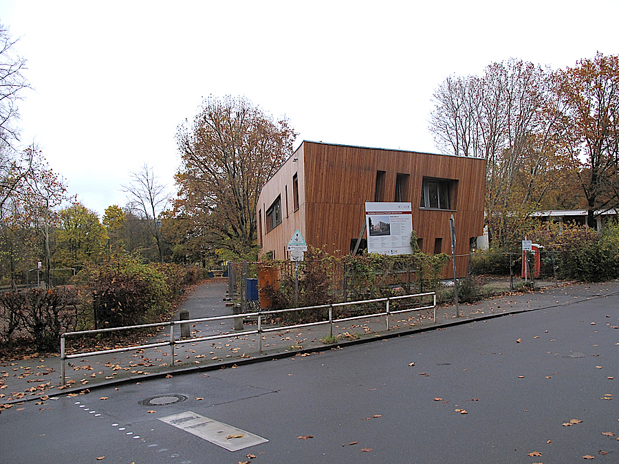 Zweistöckiges, unregelmäßiges Gebäude mit Holzfassade an Straße im Herbst