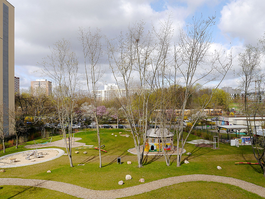 Blick von oben auf Rasen, geschwungenen Weg, Bäume im Frühling, Baumhaus